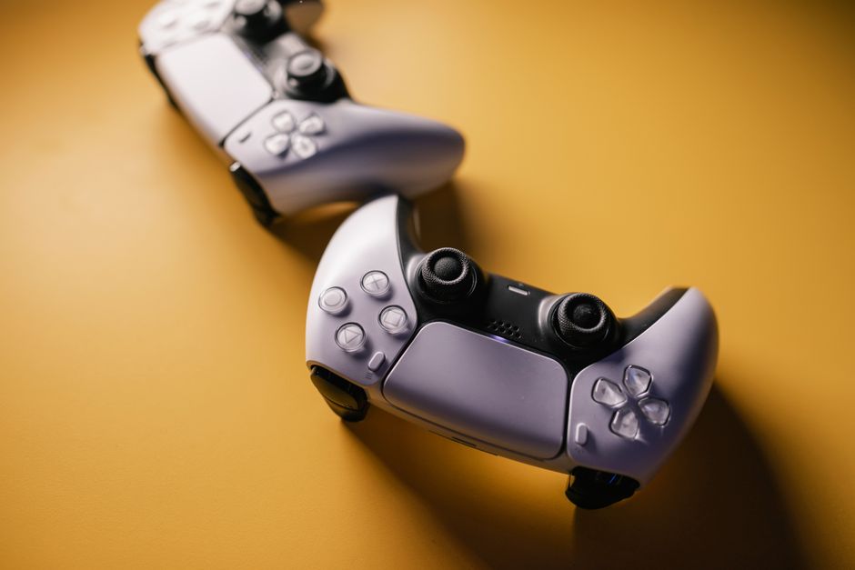 Pair of modern game controllers placed against a vibrant backdrop, emphasizing gaming and technology.